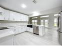 Bright, renovated kitchen featuring white cabinets, stainless appliances, and a center island at 1155 Orange Grove Ln, Apopka, FL 32712