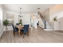 Bright dining room features wood floors, modern chandelier, and staircase with black iron railing at 13643 Budworth Cir, Orlando, FL 32832