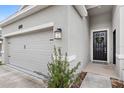 Close-up of home's garage, front door adorned with a wreath, and tidy landscaping at 1443 Lassen St, Haines City, FL 33844