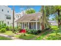 Charming home featuring a quaint front porch and vibrant red stairs nestled in a lush green yard at 204 Park Lake St, Orlando, FL 32803