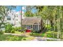 Charming home featuring a quaint front porch and vibrant red stairs nestled in a lush green yard at 204 Park Lake St, Orlando, FL 32803