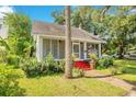 Charming home featuring a quaint front porch and vibrant red stairs nestled in a lush green yard at 204 Park Lake St, Orlando, FL 32803