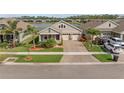 Aerial view of a single-Gathering home boasting a two-car garage, lush landscaping and serene lake views at 211 Venetian Palms Blvd, New Smyrna Beach, FL 32168
