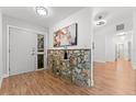 Inviting entryway featuring wood floors, stone accent wall, and modern decor at 221 W Berkshire Cir, Longwood, FL 32779