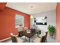 Cozy dining room featuring bright orange walls, a decorative painting, and a window with natural light at 224 Lewfield Cir, Winter Park, FL 32792