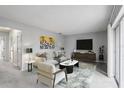 Bright living room with neutral walls, plush carpet, stylish furniture, and a large sliding glass door at 224 Lewfield Cir, Winter Park, FL 32792