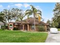 Inviting single-Gathering home featuring a lush green lawn, mature landscaping, and a covered entryway at 30837 Westridge Ter, Sorrento, FL 32776