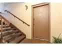 Stairway leading to Unit 242 with a brown front door and plants in the hallway at 626 Orange Dr # 242, Altamonte Springs, FL 32701