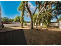 Spacious backyard with mature trees and a white privacy fence at 8322 Lake Lucy Dr, Orlando, FL 32818