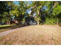 View of the home from the side yard surrounded by mature landscaping at 8322 Lake Lucy Dr, Orlando, FL 32818
