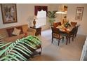 Inviting living room and dining area with neutral carpet, wooden furniture, and bright natural light at 913 Henley Cir, Davenport, FL 33896