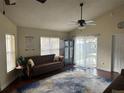 Vaulted ceiling living room with wood floors, area rug, sofa, and access to the backyard at 10313 Crystal Point Dr, Orlando, FL 32825