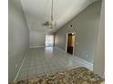 Open-concept living space featuring vaulted ceilings and tile flooring at 1103 Jade East Ln # 1103, Kissimmee, FL 34744