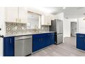 Modern kitchen featuring stainless steel appliances, granite countertops, and stylish blue and white cabinets at 11643 Sw 137Th Loop, Dunnellon, FL 34432