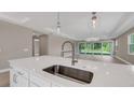 Spacious kitchen island featuring a modern faucet, stainless steel sink, and view of the sliding glass doors to the lanai at 1251 Cresswind Blvd, Deland, FL 32724