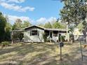 Charming single-story home with a carport and well-kept front lawn showcasing its inviting curb appeal at 1348 Cr 605, Bushnell, FL 33513