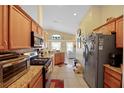 Spacious kitchen featuring wood cabinets, granite countertops, and stainless steel appliances at 136 Majestic Forest Run, Sanford, FL 32771