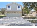 Two-story home showcasing a spacious driveway and a lush front lawn at 1368 Falconwood Ct, Apopka, FL 32712