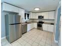 Modern kitchen features stainless steel appliances and white cabinetry at 1416 Braebury Dr, Leesburg, FL 34748