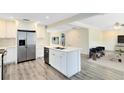 Bright, open kitchen features white cabinets, stainless steel appliances, and island with seating at 2208 Page Ave, Orlando, FL 32806