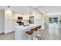 Modern eat-in kitchen featuring white cabinets, stainless appliances, and a large island with bar stool seating at 2208 Page Ave, Orlando, FL 32806