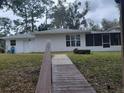 The back of the home features a back door, screen patio, and yard at 2215 Hontoon Rd., Deland, FL 32720