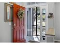 Inviting entryway with a stylish red door and decorative wreath at 525 Gentle Breeze Dr, Minneola, FL 34715