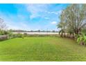 Spacious backyard featuring lush green grass and a tranquil view of the water, creating a serene outdoor space at 5380 Barton Dr, Orlando, FL 32807