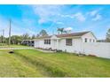 Charming single-story home with white siding, complemented by a lush green lawn and blue skies at 5380 Barton Dr, Orlando, FL 32807