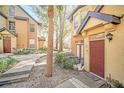Charming townhome featuring a cozy patio, lush landscaping, and a welcoming red front door with a modern design at 6356 Raleigh St # 1512, Orlando, FL 32835