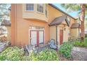 Inviting patio area with outdoor seating, complemented by lush green landscaping and a welcoming red front door at 6356 Raleigh St # 1512, Orlando, FL 32835