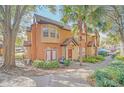 Attractive two-story townhome with manicured landscaping, a welcoming red front door, and a cozy front patio at 6356 Raleigh St # 1512, Orlando, FL 32835