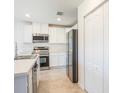 Well-lit kitchen with stainless steel appliances, white cabinets, and modern fixtures at 814 Massy Ct, Kissimmee, FL 34759