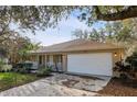 Front exterior of home with garage and landscaped front yard with covered porch at 820 Cypress Oak Cir, Deland, FL 32720