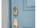 A close-up view of a modern digital lock, with the hardware and a blue door at 10437 Ebb Tide Ln, Orlando, FL 32821