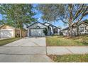 Charming one-story home with mature trees, well-manicured lawn, and paved driveway at 1136 Twin Rivers Blvd, Oviedo, FL 32766