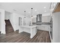 Stylish kitchen featuring a central island with pendant lights, modern cabinets, and hardwood flooring at 13062 Sunrise Harvest Dr, Winter Garden, FL 34787