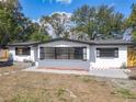 A beautifully renovated single Gathering home with a gray brick facade below a wall of floor to ceiling windows at 1382 Wright St, Daytona Beach, FL 32117