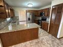 A well-lit kitchen showcasing granite countertops, stainless steel appliances, and wooden cabinetry at 1811 Springwood Ln, Deltona, FL 32725