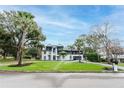 Wide exterior of home featuring a manicured lawn, mature trees, and a paved driveway at 2721 Ingeborg Ct, Windermere, FL 34786