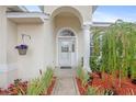 Inviting front entrance with decorative glass door, column and manicured landscaping at 3203 Victoria Ln, Eustis, FL 32726