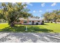 Charming single-story home with a lush green lawn, inviting curb appeal, and mature shade trees at 522 Wisconsin Ave, St Cloud, FL 34769