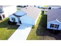 An aerial view of a single-Gathering home featuring an attached two-car garage, complemented by a lush green lawn at 6910 Se 111Th Pl, Belleview, FL 34420