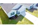 An aerial view of a single-Gathering home featuring an attached two-car garage, complemented by a lush green lawn at 6910 Se 111Th Pl, Belleview, FL 34420