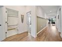 Hallway featuring wainscoting, hardwood floors, and views into the bathroom and other rooms at 704 Hyperion Dr, Debary, FL 32713