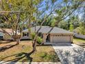 Inviting single-Gathering home with a spacious driveway, mature trees, and manicured lawn at 7448 Grand Ct, Winter Park, FL 32792