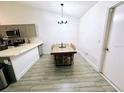 Bright dining area showcases wood-look tile floors, a long wooden table, and a modern chandelier at 7885 Brockwood Cir, Orlando, FL 32822