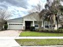 Beautiful facade of a well-maintained home, showing garage, nice lawn and an inviting entrance at 8744 Currituck Sound Ln, Orlando, FL 32829