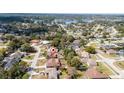 Scenic aerial view of a residential neighborhood featuring a home with a brown roof near a serene lake at 986 Sweetbrier Dr, Deltona, FL 32725