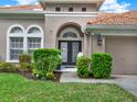 Inviting front entryway features a decorative glass door, manicured shrubs, and a well-maintained lawn at 11327 Ledgement Ln, Windermere, FL 34786